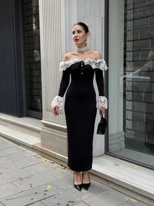 Détail de la robe noire à épaules dénudées avec dentelle blanche et boutons perles