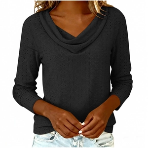 Detail view of black long sleeve top featuring intricate eyelet hollow-out fabric and cowl neck
