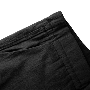 Detail view of cotton linen trousers featuring elastic waistband and side pocket stitching