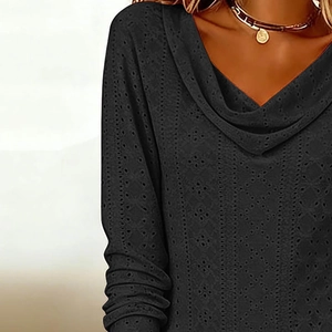 Detailed view of black long-sleeve dress with eyelet embroidery and draped cowl neckline