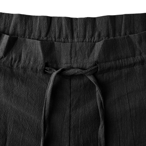 Detail view of high waist elastic waistband with adjustable drawstring on black linen pants