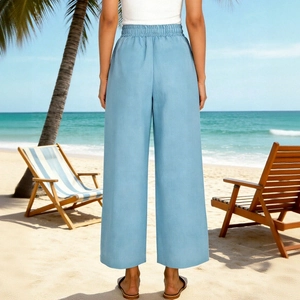 Vista posteriore dei pantaloni a gamba larga azzurri su una spiaggia tropicale