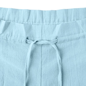 Detailed close-up of light blue cotton linen pants featuring elastic drawstring waistband