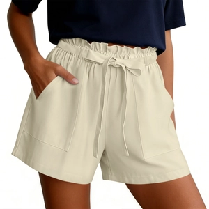 Detail of high waisted beige paper-bag shorts with drawstring and large side pockets