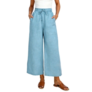 Dettaglio dei pantaloni larghi in lino azzurro con vita elastica a coulisse e ampie tasche
