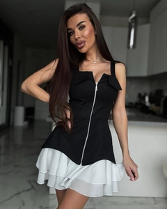 Détail d'un top noir ajusté avec zip et d'une jupe blanche à plusieurs couches