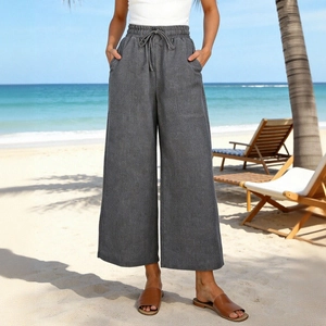 Dettaglio dei pantaloni in lino a vita alta con coulisse e ampie tasche applicate frontali