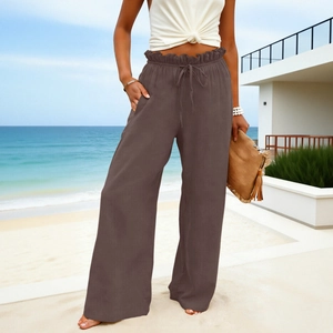 Detail of high waisted brown wide leg trousers featuring a ruffled drawstring waist