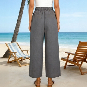 Vista posteriore dei pantaloni grigi a vita alta e gamba larga in una spiaggia soleggiata