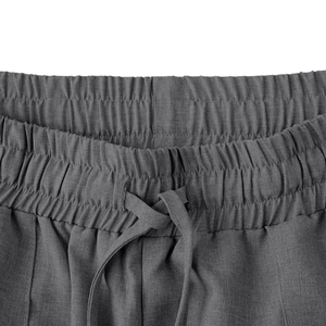 Dettaglio dell'elastico in vita e della coulisse sui pantaloni casual grigio scuro