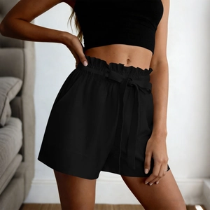 Detail of high waisted black paperbag shorts with elastic drawstring waist and bow belt