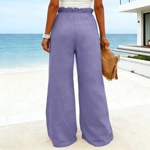 Rear view of lavender high waisted cotton linen wide leg trousers on a beach background
