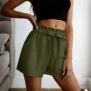 Detail of high waisted paperbag shorts in olive green with drawstring bow and side pockets