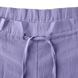 Detail view of the drawstring elastic waistband and linen fabric texture of purple pants