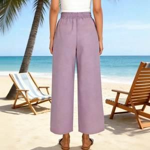 Vista posteriore dei pantaloni color lavanda a vita alta e gamba larga in spiaggia