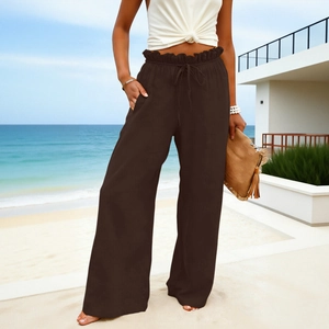 Detail of high-waisted linen wide-leg pants featuring drawstring and ruffled paperbag waist