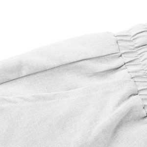 Dettaglio macro della fascia elastica in vita e delle tasche laterali dei pantaloni bianchi