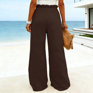 Back view of high-waisted linen-blend dark brown wide-leg pants on beach setting