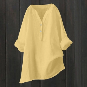 Detail of light yellow cotton linen blouse with V-neckline and button accents