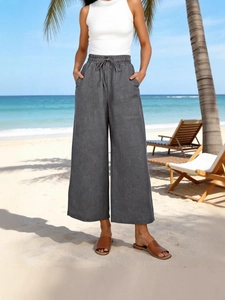 Pantaloni larghi a vita alta da donna con coulisse e tasche sulla spiaggia