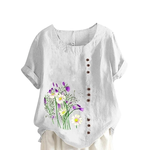 Detail of white cotton linen top featuring floral prints and dark decorative buttons