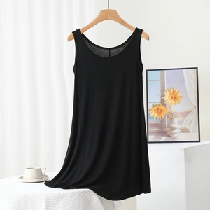 Detail of a black sleeveless modal dress hanging on a wooden hanger in a home setting