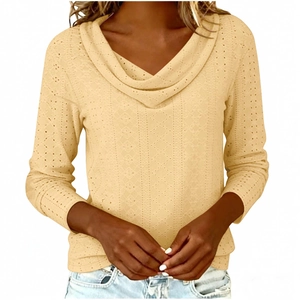 Detail of light yellow V-neck top showing delicate eyelet embroidery and cowl neck texture