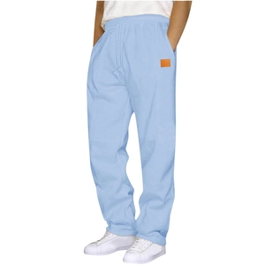 Detail of light blue joggers featuring an elastic drawstring waist and orange logo patch