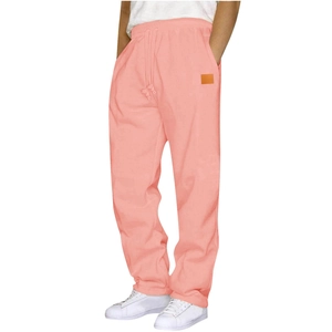 Men's casual pink joggers featuring an elastic drawstring waist and orange logo patch