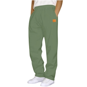 Detail of olive green sweatpants with elastic waist and orange square decorative patch