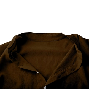 Détail du tissu froissé marron foncé avec bouton blanc et texture du col officier