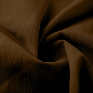 Vue macro d'un tissu texturé marron foncé montrant le drapé et la qualité