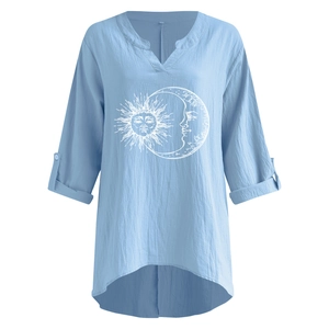 Détail d'un chemisier bleu clair en lin avec col en V et motifs soleil et lune