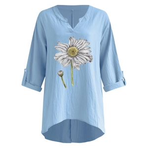 Detail of light blue cotton linen shirt with white daisy print and V-neckline finish