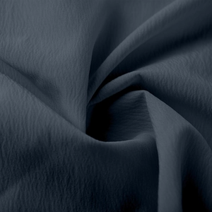 Détail macro du tissu crêpe bleu foncé avec des plis élégants et un drapé doux