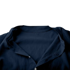 Détail d'un col montant bleu marine texturé avec coutures fines et bouton transparent