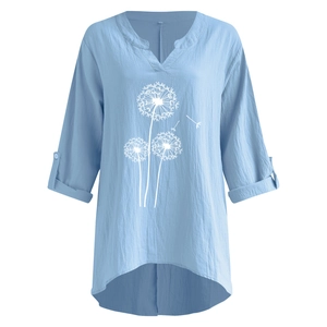 Détail de la blouse en lin bleu clair avec col en V et motif de pissenlit blanc