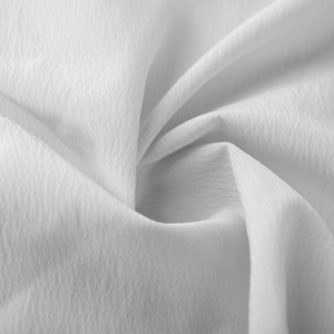 Gros plan détaillé sur un tissu blanc léger avec une texture froissée naturelle