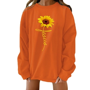 Close-up of sunflower print with Jesus lettering on orange crewneck sweatshirt