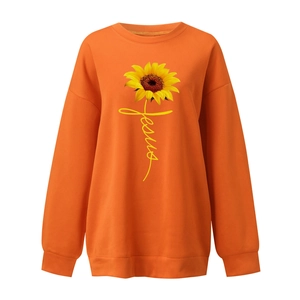 Close-up of vibrant orange sweatshirt featuring sunflower print and Jesus script detail