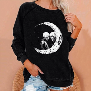 Close-up of loose black Halloween sweatshirt featuring moon and skull graphic print