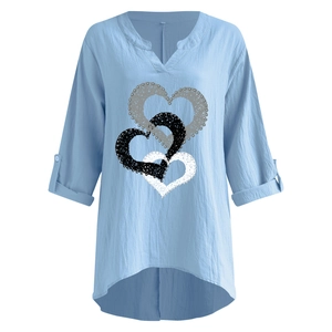 Dettaglio della camicia in lino azzurra con scollo a V, stampa cuore e maniche con risvolto