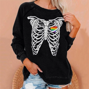 Detail of black sweatshirt featuring a rib cage skeleton print and rainbow heart accent