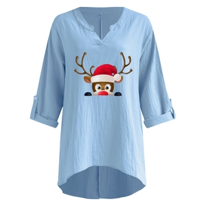 Detail der hellblauen Weihnachtsbluse mit V-Ausschnitt und Rentierdruck auf Baumwollleinen