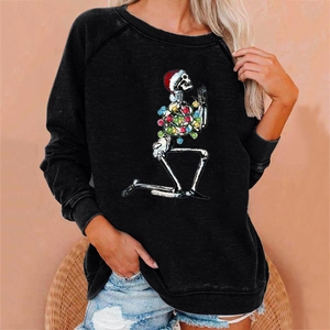 Close-up of a festive skeleton print with Christmas hat and lights on a black sweatshirt