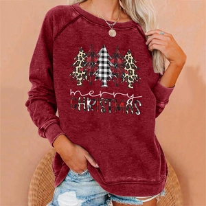Detail view of burgundy sweatshirt featuring festive Christmas trees and merry text