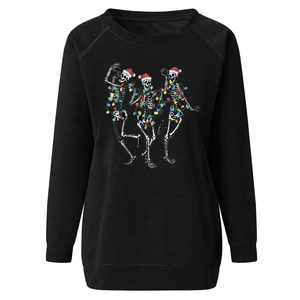 Close-up of three dancing skeletons wearing Santa hats on a black sweatshirt