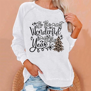 Detail of white Christmas sweatshirt featuring leopard tree print and festive holiday text