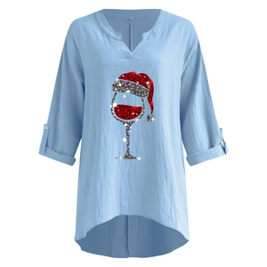 Detail der hellblauen Leinenbluse mit V-Ausschnitt und glitzerndem Weihnachts-Weinglas-Druck