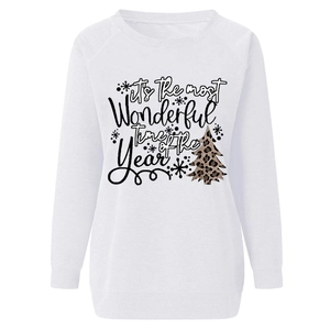 Close-up of Christmas leopard tree print and festive lettering on white sweatshirt